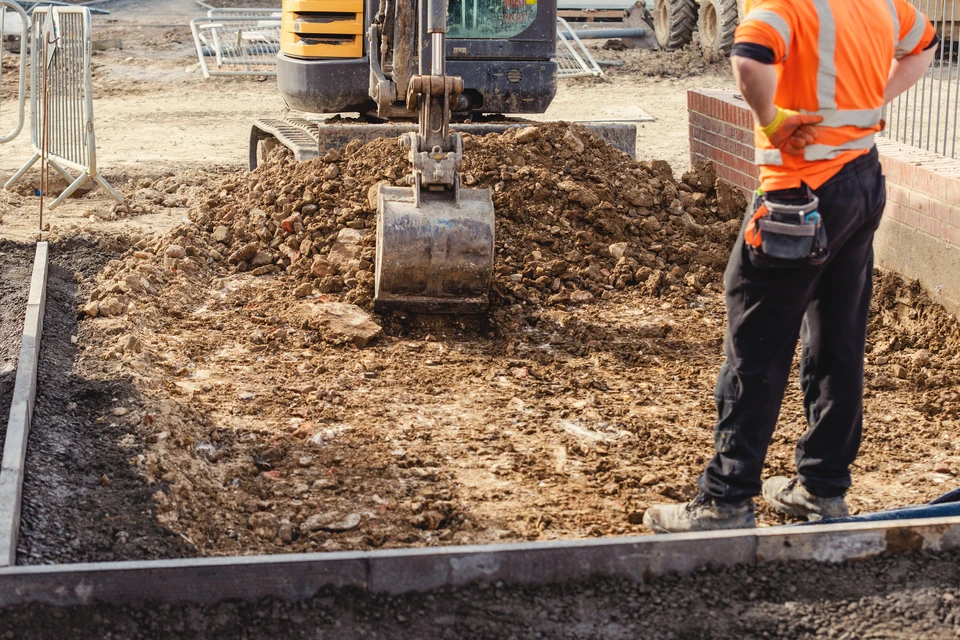 Chantier de construction extérieur avec engins de terrassement opérant sur terrain en pentes